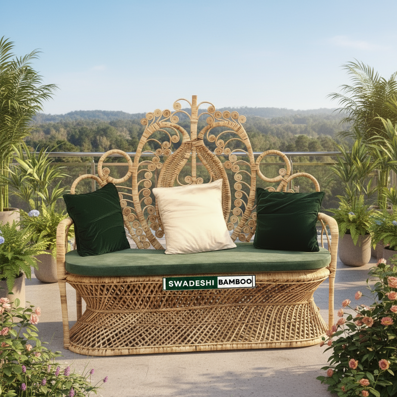 Wicker outdoor bench with cushions and 'Swadeshi Bamboo' label on a patio with plants and flowers.