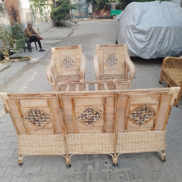 Wicker furniture set on a street with a car and person in the background
